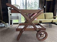 Side view showing wooden angled frame, rear wheels, and tray resting on lower shelf.