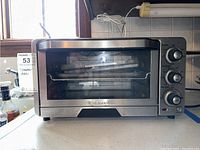 Front view of Cuisinart TOB-40 toaster oven showing stainless steel framed glass door and three control knobs on the right side.