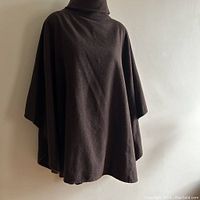 Front and draped view of the poncho, showing its smokey brown wool material and shape.