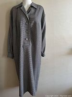 Front view of long sleeve dress with button front and collar, showing the black and white houndstooth pattern.