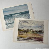 Two Canadian art prints shown side by side on a white background. One depicts an ocean wave scene, the other a rural landscape with clouds.