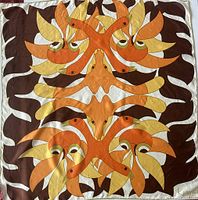 Full view of the square silk scarf showing symmetrical bird design in orange, yellow, brown, and white colors with hand-rolled hems.