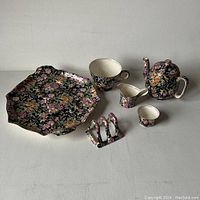 Full set laid out on a surface showing all items separately with the floral chintz pattern and gold trim visible