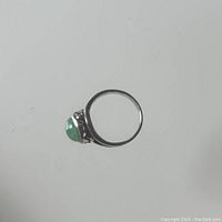 Side view of the sterling silver ring showing profile of jade stone setting and band.