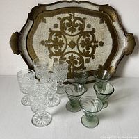 Photo showing the vintage Venetian tray with golden and taupe tones, placed behind five green Mexican sherry glasses and five clear cut glass sherry glasses.