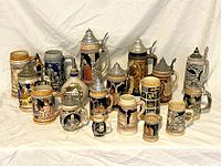 Full group view of 15 assorted vintage beer steins arranged in rows, showing varied sizes, colors and metal lids.