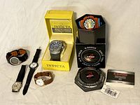 Five watches including Casio G-Shock, Invicta in box, and three other analog watches