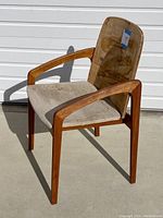 Full view of chair angled to show front and left side, highlighting wooden frame and upholstery condition.