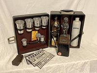 Closed brown leather travel bar case with shot glasses and liquor bottles visible, including Johnnie Walker bottle and ceramic crock