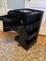 Angled front view with drawers extended, side compartments and wheels visible