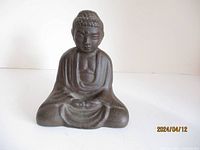 Front view of the cast iron Buddha figurine showing the detailed face and robe.