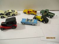 Six die cast model cars including sedan, convertible, pickup truck, and vintage styles arranged on a white background.