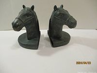 Pair of dark horse head bookends shown from front angle on white background, illustrating shape and detail.