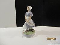 Front angle view of the Royal Copenhagen porcelain figurine with lady and goose on round base