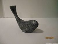 Front side view of the dark gray soap stone seal sculpture showing polished surface and shape