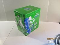Green Steam Whistle branded metal cooler with handle and blue/white graphics