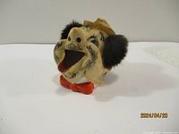 Front view of the vintage tramp ashtray showing character face, hat, fuzzy ear-like attachments, open mouth with red tongue and painted stubble.