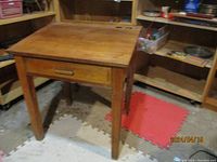 Front and side view of vintage wooden school desk showing the full desk and drawer closed.
