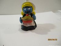 Front view of the female Smurf figurine holding a pie