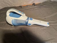 Right angle view of Black & Decker Dustbuster handheld vacuum cleaner showing ergonomic handle, blue and white coloring.