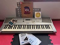Yamaha electric keyboard with music books and CDs placed on top including Grateful Dead book and piano chord dictionary