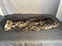 Full length view of the fleece lined camo hunting pants laid flat showing camo pattern and ankle cuff.