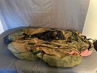 Fly fishing inner tube laid out on a surface showing its olive green and brown fabric.