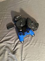 Gaming controllers and computer mouse with wireless dongles arranged on fabric surface.