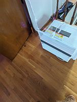 Side view of white GE window air conditioner, showing adjustable side panel and venting.