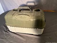 Full side view of large plastic tackle box showing the olive green top and beige bottom with handle