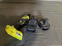 Ryobi cordless power ratchet and two 18V batteries on a surface showing overall condition.