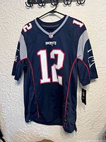 Front view of the navy blue Tom Brady New England Patriots football jersey with number 12 and Patriots logo.