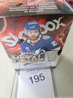 Sealed front side of 2021-22 Skybox Metal Universe hockey trading card box, featuring a hockey player image and series branding.