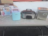 Front view of two ice machines and one electric roaster on table