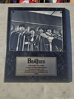 Full view of the Beatles black and white photo and the engraved plaque on a black marble-style background.