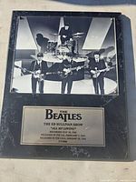 Close-up photo of the black and white Beatles performance photo and the plaque with song information.