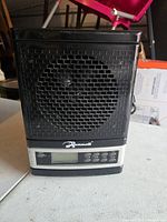 Front view of black Mammoth air purifier showing the fan behind mesh and control panel with buttons and display below.