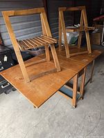 Table with both drop-leaves folded and two chairs stacked on top