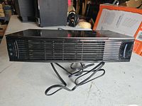 Front and top angled view of the Oreck air purifier showing slatted vent and control buttons with icons.