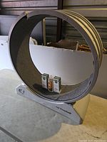 Large circular cat treadmill on table, showing carpeted track and base with 'Cat Treadmill' label. Used condition with seam damage.