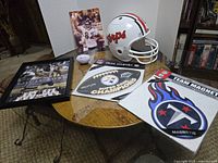 Wide photo showing football memorabilia including Maryland Terps helmet, framed photo, small football, Pittsburgh Steelers and Tennessee Titans magnets, and a photo print.