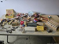Full lot overview showing all vintage sewing supplies arranged on table including spools of thread, scissors, sewing basket, buttons, powders, and accessories.