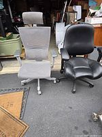 Two ergonomic office chairs side by side - black padded chair and gray mesh chair