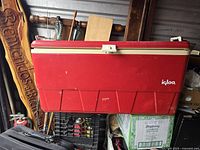 Side view of red vintage Igloo cooler with white latch and embossed brand name