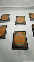 Six stacks of Magic the Gathering cards with visible card backs shown in each photo.