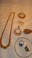 Photo shows full lot including gold plated rope chain necklace, Neptune coin, two turquoise rings, sterling cuff bracelet, two pendants, and keychain fob with turquoise stone.