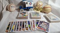 Wide view of the collection showing all autographed baseballs, toy truck, and baseball cards in cases and loose