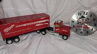 Full view of the Milwaukee Sawzall model truck with trailer and Skilsaw shop blade clock set against a white backdrop.