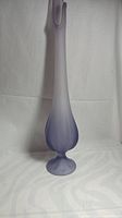 Full view of tall narrow purple frosted glass vase with rounded bulbous base and pedestal foot.