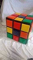 Front and side view of large cube shaped toy box with vinyl squares mimicking Rubik's Cube colors and pattern